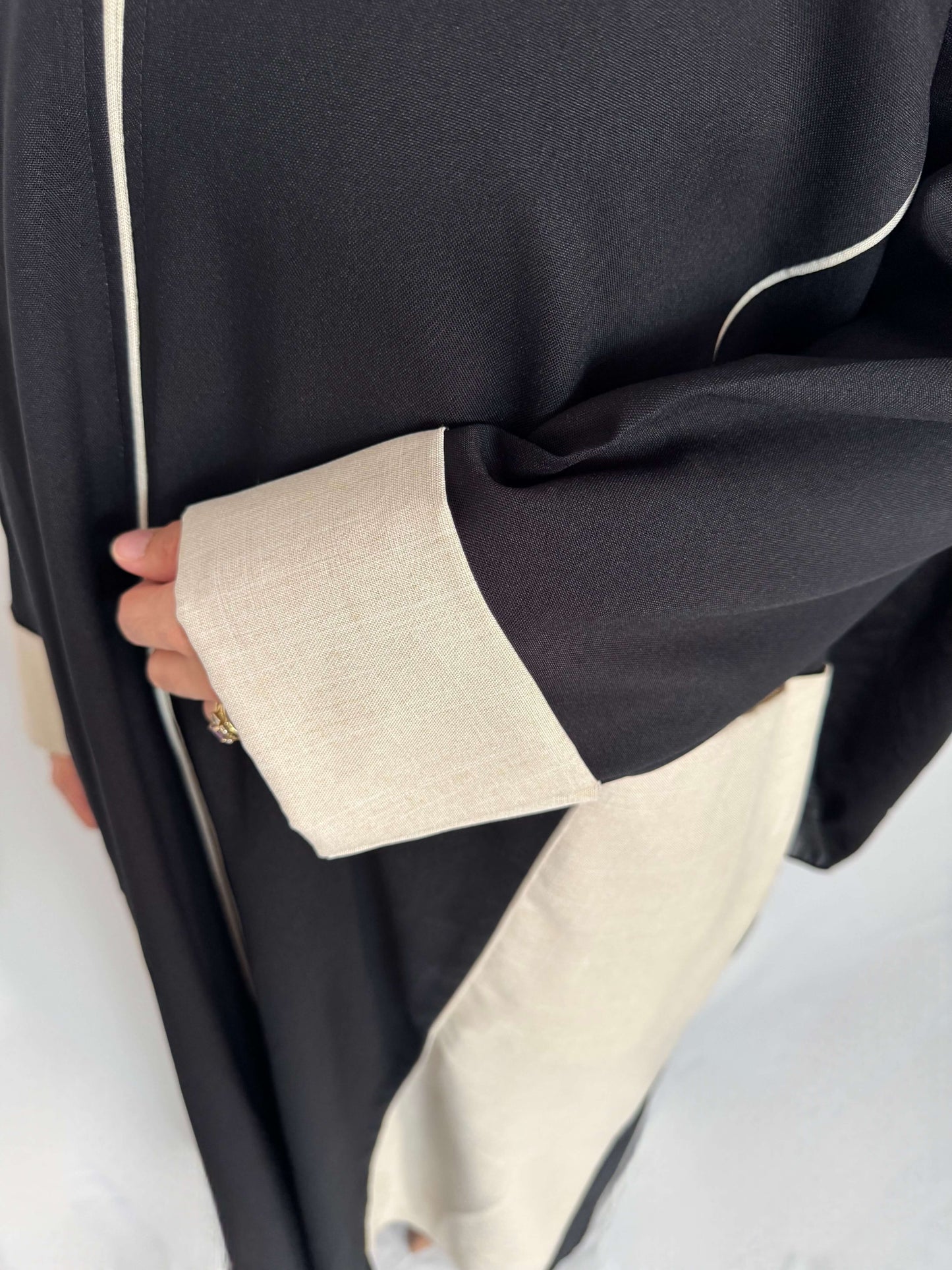 Zoom sur le tissus de la abaya lina et sur les manches avec un rappel de tissus beige