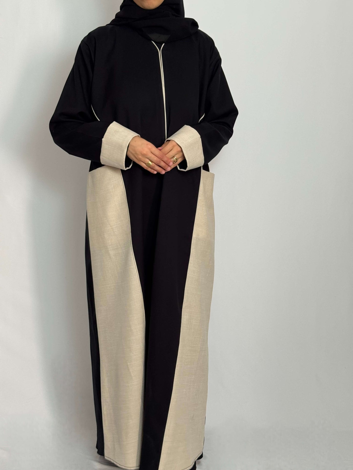 Abaya Lina noir et blanche vue de face longue et fluide portée par une femme voilée