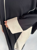 Zoom sur le tissus de la abaya lina et sur les manches avec un rappel de tissus beige 